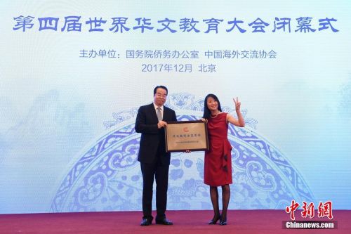 12月20日，第四屆世界華文教育大會(huì)在北京閉幕。圖為國(guó)務(wù)院僑務(wù)辦公室黨組書記、副主任許又聲(左)向法國(guó)小熊貓學(xué)校校長(zhǎng)羅堅(jiān)海外華文教育示范學(xué)校授牌。 <a target=