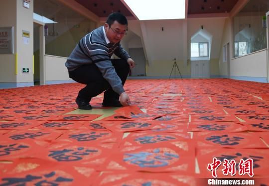 黃帥小心翼翼地將他書寫的福字放在地上展示 張瑤 攝 黃帥小心翼翼地將他書寫的福字放在地上展示 張瑤 攝